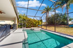 an indoor swimming pool in a house with glass walls at Sundrop Villa in Davenport
