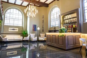 a lobby with a bar with chairs and a chandelier at Hotel Viminale in Rome