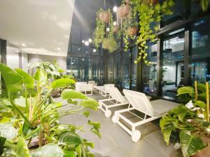 a room filled with lots of plants and white lounge chairs at Melbourne Luxury Apartment Steps away from Crown in Melbourne