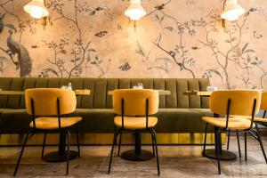 um restaurante com cadeiras amarelas e uma parede com flores em Hotel Viminale em Roma