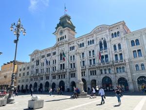 un grand bâtiment avec des gens qui marchent devant dans l'établissement Bilocale CAVANA LIFE, à Trieste