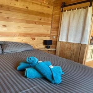 un animal de peluche azul en una cama en una habitación en La roulotte du verdon, en Quinson