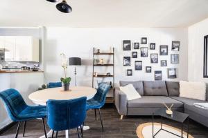 ein Wohnzimmer mit einem Sofa, einem Tisch und Stühlen in der Unterkunft appartement cosy au port de Cancale in Cancale