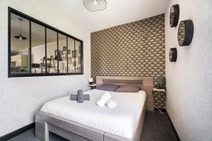 Schlafzimmer mit einem weißen Bett und einem Spiegel in der Unterkunft appartement cosy au port de Cancale in Cancale