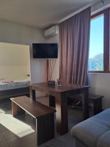 a living room with a table and a couch and a window at Sofi II in Niš