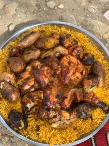 a bowl of food with chicken and mushrooms on yellow rice at Bedouin Panorama House in Wadi Musa