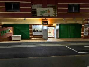 a building with green garage doors on a street at Sea View Court Kobe in Kobe