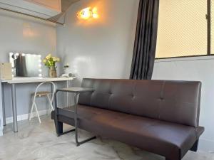 brązowa kanapa w pokoju ze stołem w obiekcie Sea View Court Kobe w mieście Kobe