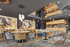 a restaurant with tables and chairs and a bar at LE RITUEL HOTEL & SPA in Honfleur