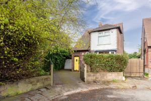 a white house with a yellow door at Fantastic, modern 3 bedroom house in Manchester