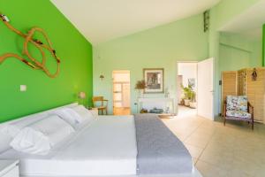 a bedroom with a white bed in a green wall at Spacious Villa by the sea in Pefkali
