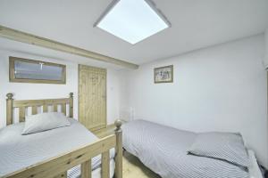 1 dormitorio con 2 camas y tragaluz en Loft en duplex avec balcon et vue en Arreau