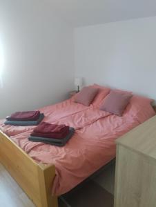 uma cama com lençóis e almofadas cor-de-rosa em Kuća za odmor Jezero em Ostrovo