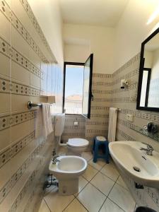 bagno con due servizi igienici, lavandino e finestra di Hotel Romagna a Cesena