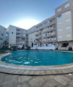 an empty swimming pool in front of a building at appartement 14 in Chott Meriem