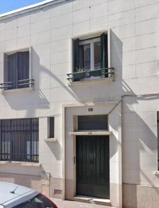 ein Gebäude mit einer grünen Tür und zwei Fenstern in der Unterkunft Escale à Nairobi-Portes de Paris-PARKING in Saint-Ouen