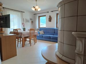 een woonkamer met een blauwe bank en een tafel bij Casa Erica in Falcade