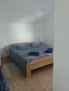 um quarto com uma cama com lençóis azuis em Kuća za odmor Jezero em Ostrovo