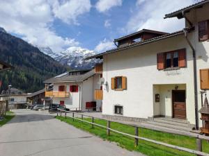 a street in a village with mountains in the background at Casa Erica in Falcade