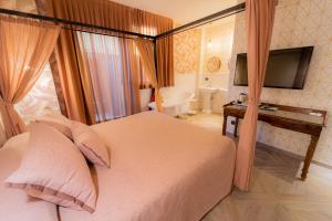 a bedroom with a bed and a television and a bathroom at Hotel Il Guercino in Bologna