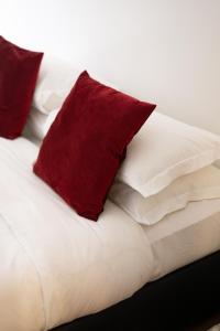 uma cama branca com almofadas vermelhas em 34 Home in Rome em Roma