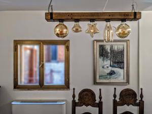a room with two chairs and a window and lights at Casa Micisca - Pescasseroli Centro in Pescasseroli