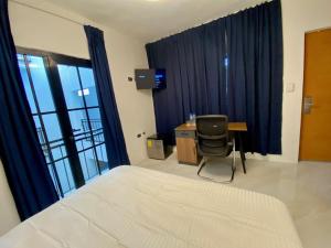 a bedroom with a bed and a desk and a chair at RIG Colonial Experience in Santo Domingo