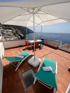 een balkon met een tafel en stoelen en een parasol bij Casa Positano in Positano
