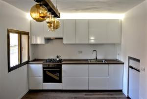 a kitchen with white cabinets and a sink at Casa Micisca - Pescasseroli Centro in Pescasseroli