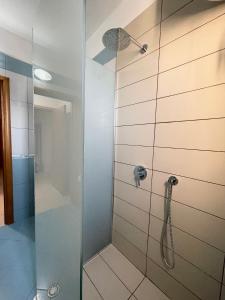 y baño con ducha y puerta de cristal. en Deni Apartment, en Vlorë