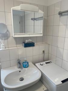 a white bathroom with a sink and a mirror at Apartment Rot-Kreuz in Bad Säckingen