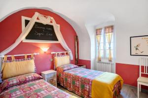 a bedroom with two beds and a chalkboard on the wall at Casa Maria in Dolcedo