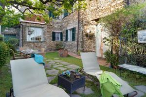 a patio with two chairs and a table in a yard at Casa Maria in Dolcedo