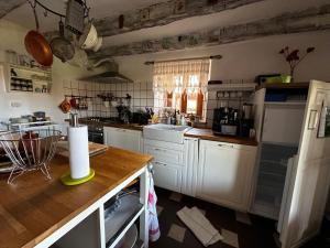 a kitchen with white cabinets and a counter top at The Shire in Poljane