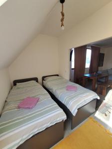 two twin beds in a room with a table at Sofi II in Niš