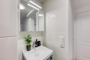 Baño blanco con lavabo y espejo en Apt near Paris & CDG & Expo & SDF & Disney, en Livry-Gargan