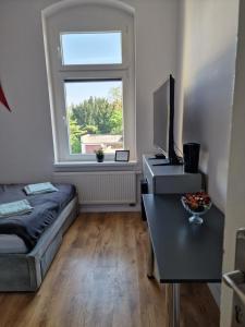 a small living room with a bed and a window at Apartamenty Zakonne "Apartament Rycerza" in Malbork