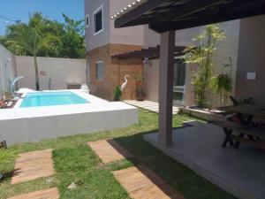 a backyard with a swimming pool and an umbrella at Recanto da Sulla - JAUÁ in Jauá +18 photos