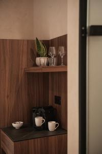 a shelf with cups and wine glasses on it at Copal Simple Staying in Chania