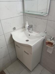 a white bathroom with a sink and a mirror at Braća Kosorić in Han Pijesak