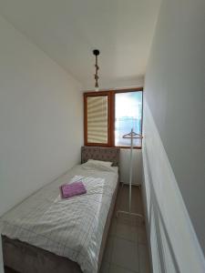 a small bedroom with a bed and a window at Sofi II in Niš