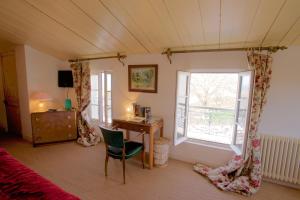 a bedroom with a desk and a bed and a window at Le Corps de Garde in Saint-Martin-de-Ré