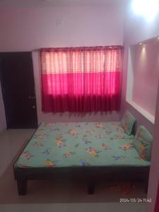 a bed in a room with a pink window at Dwarka Home Stay 2 Only family in Dwarka