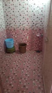 a bathroom with two buckets on a tiled floor at Dwarka Home Stay 2 Only family in Dwarka