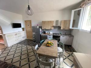 a kitchen with a table with a bowl of fruit on it at Trullo Del Salento in San Vito dei Normanni