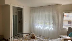 a room with a window with a curtain and a chair at Casa vacanze da Roberta a pochi km da Oristano in Simaxis