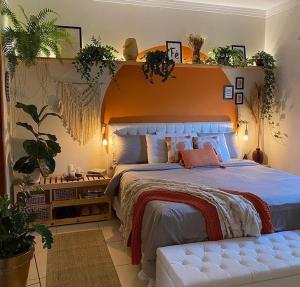 - une chambre avec un grand lit et une tête de lit orange dans l'établissement Art riad au bord de la mer 2, à El Jadida