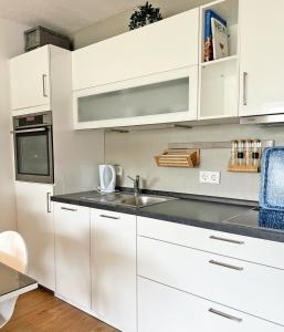 a kitchen with white cabinets and a sink at Driftberg 1 Whg 18 in Grömitz