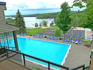a swimming pool with chairs and a view of a lake at Hidden Valley Resort, an Ascend Collection Resort in Huntsville