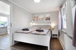 a bedroom with a white bed with two pillows on it at Boddenferienhaus - 13 Treibholz in Schaprode